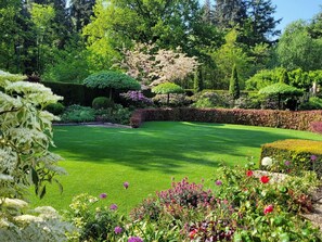 A well-manicured garden with a variety of flowering plants and neatly trimmed hedges. - Villa in Overloon Near War Museum and Zoo (Overloon)