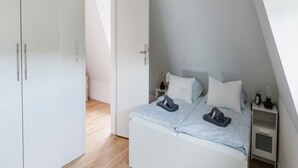 Une chambre à coucher avec un lit, une table de chevet et une armoire.