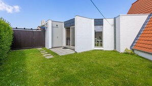 A modern house with a small backyard, a wooden fence, and a clear sky. - Peacefully Located Holiday Home Near the sea (Middelkerke)