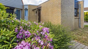 A modern building with a brick facade, a visible door, and a small window. - Peacefully Located Holiday Home Near the sea (Middelkerke)