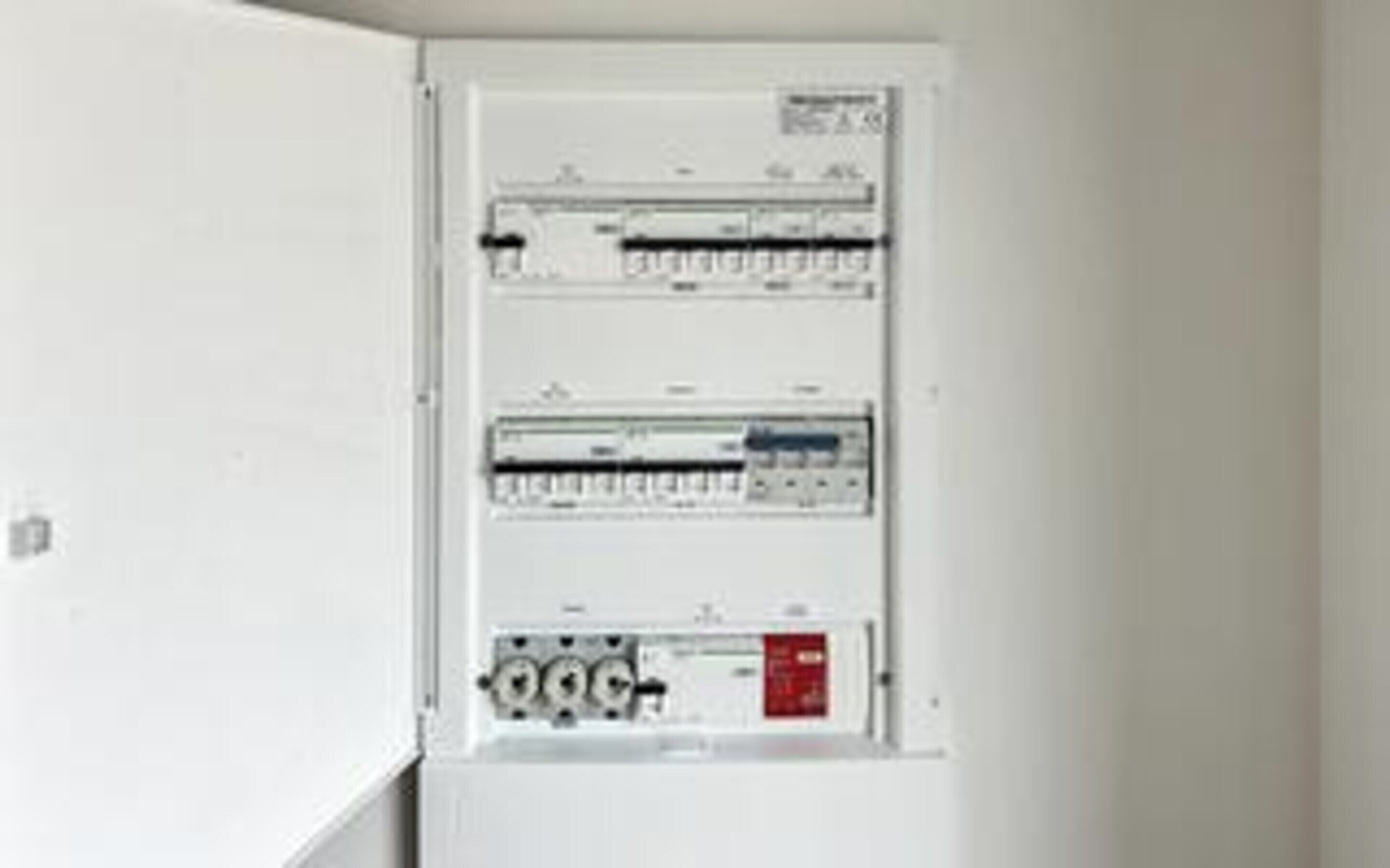 A white electrical panel with multiple switches and circuit breakers.