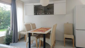 Una cucina moderna con mobili bianchi, forno integrato e frigorifero.