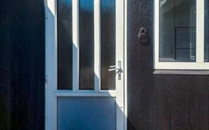 A door with a white frame and a glass panel, a small window with a white frame, and a doorbell. - 6 Person Holiday Home in Skjern (Skjern)