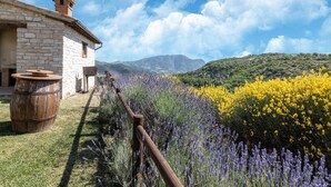 A stone building with a chimney, a barrel, and a wooden fence. - Pet-friendly Getaway (Cagli)