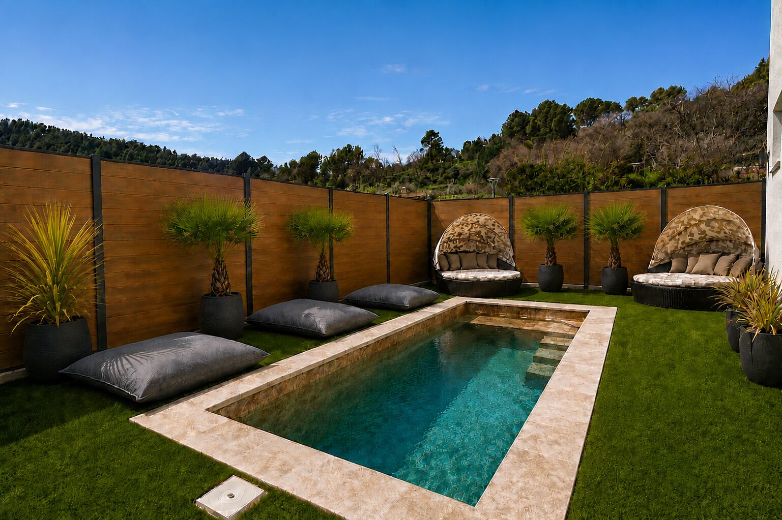 Ein rechteckiger Swimmingpool mit Holzterrasse, umgeben von Rasen und Kübelpflanzen.