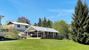 A two-story house with a covered porch and a large lawn. - 4 Star Holiday Home in Ljustero (Ljusterö)