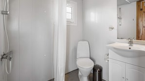 A bathroom with a shower, toilet, sink, and a trash bin. - 4 Star Holiday Home in Fjerritslev (Fjerritslev)
