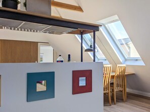 A modern kitchen with a skylight, wooden ceiling beams, and a dining area with a table and chairs. - 5 Person Holiday Home in Albaek (Aalbaek)