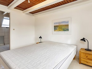 A bedroom with a large bed, two bedside tables with lamps, a wooden ceiling, and a framed picture on the wall. - 5 Person Holiday Home in Albaek (Aalbaek)