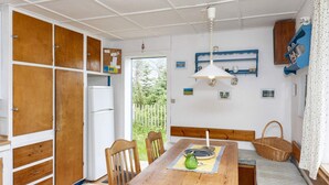 Une cuisine de taille réduite, avec des meubles de rangement en bois, une table à manger et un banc.