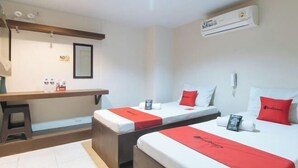 A hotel room with two beds, a desk, and an air conditioning unit. - RedDoorz @ Bridgeway Hotel Tuguegarao City (Tuguegarao)