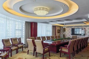 A conference room with a long table, chairs, and a chandelier.
