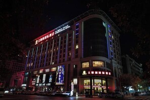 Een meerhoog hotel met verlichte signage en een opvallende ingang.