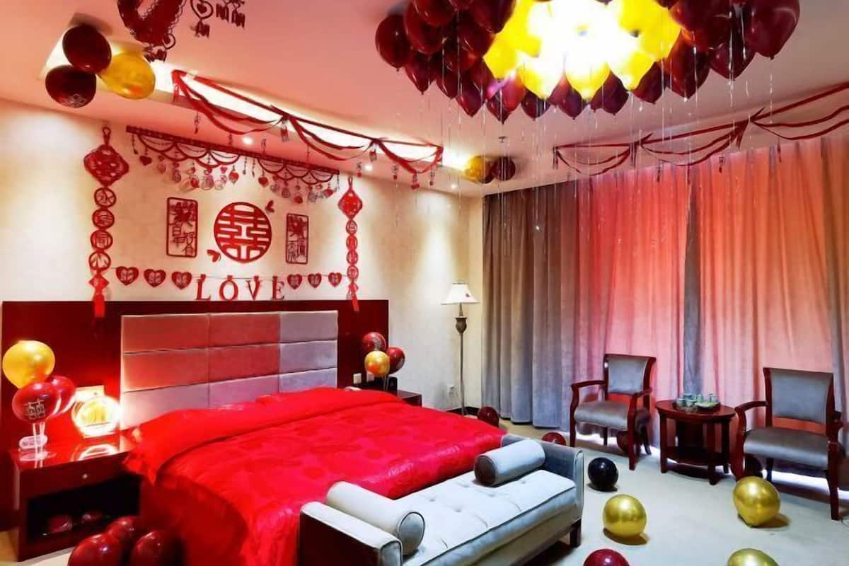 Ein Hotelzimmer mit einem großen Bett, einem Schreibtisch, zwei Stühlen und einer Kristallleuchtre.