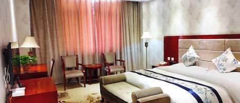 Una habitación de hotel con cama, sofá, escritorio y silla.