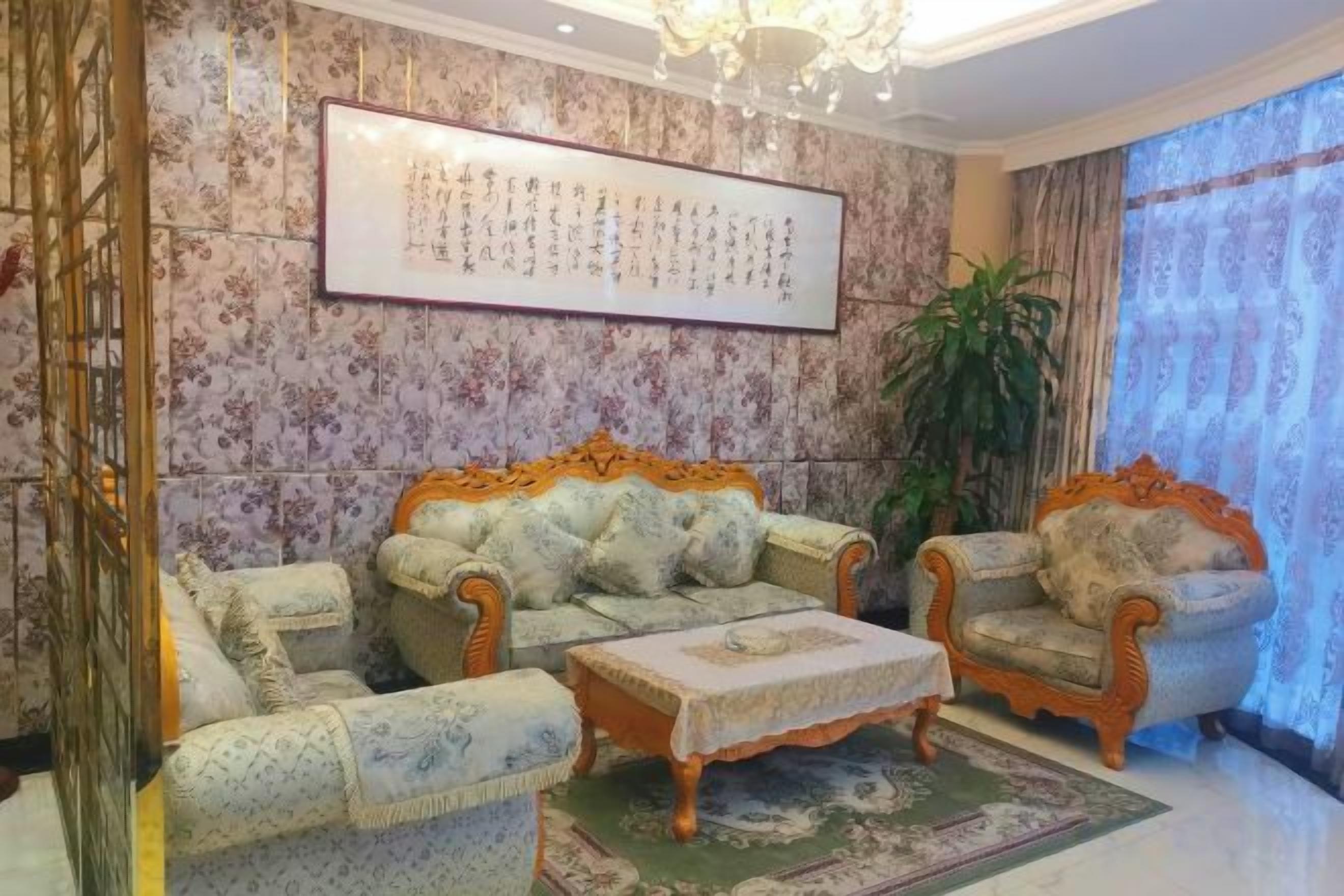 A traditional room with two sofas, a small table, and a large framed artwork on the wall.