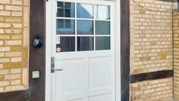 A white door with a window, a brick wall, and a small outdoor area. - 6 Person Holiday Home in Store Heddinge (Store Heddinge)
