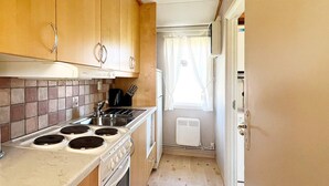 A compact kitchen with a stove, sink, and a small window. - 5 Person Holiday Home in Skummeslovsstrand (Skummesloevsstrand)