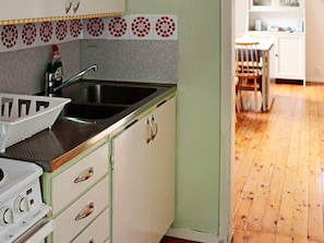 A kitchen with a sink, a Bosch stove, and a patterned backsplash. - 5 Person Holiday Home in Skummeslovsstrand (Skummesloevsstrand)