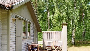 A small cabin with a porch, two chairs, and a table. - 5 Person Holiday Home in Skummeslovsstrand (Skummesloevsstrand)