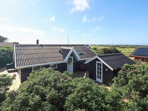 A house with a sloped roof, a small deck, and a view of the sea. - 4 Star Holiday Home in Hjorring (Hjørring)