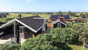 Un quartier résidentiel avec des maisons, une terrasse en bois et une vue sur la mer.