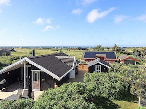 A residential area with houses, a wooden deck, and a view of the sea. - 4 Star Holiday Home in Hjorring (Hjørring)