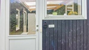 A door with a window, a nameplate, and a wooden fence.