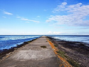 A concrete pathway leading to the sea with a clear sky above. - 8 Person Holiday Home in Hadsund (Hadsund)