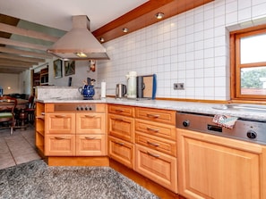 A kitchen with wooden cabinets, a built-in oven, and a stainless steel range hood. - 8 Person Holiday Home in Hadsund (Hadsund)