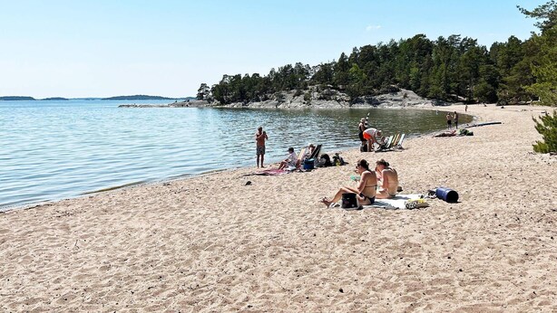 A beach with people sunbathing and swimming. - 8 Person Holiday Home in Ingaro (Ingaro)