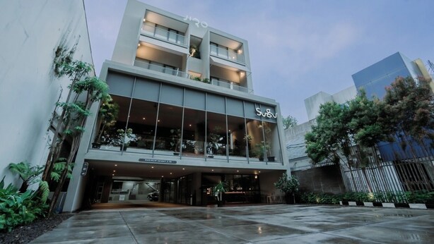 Un bâtiment moderne doté d’une façade en verre, d’une enseigne indiquant « SVV  » et d’une hauteur maximale de 2,1 m.