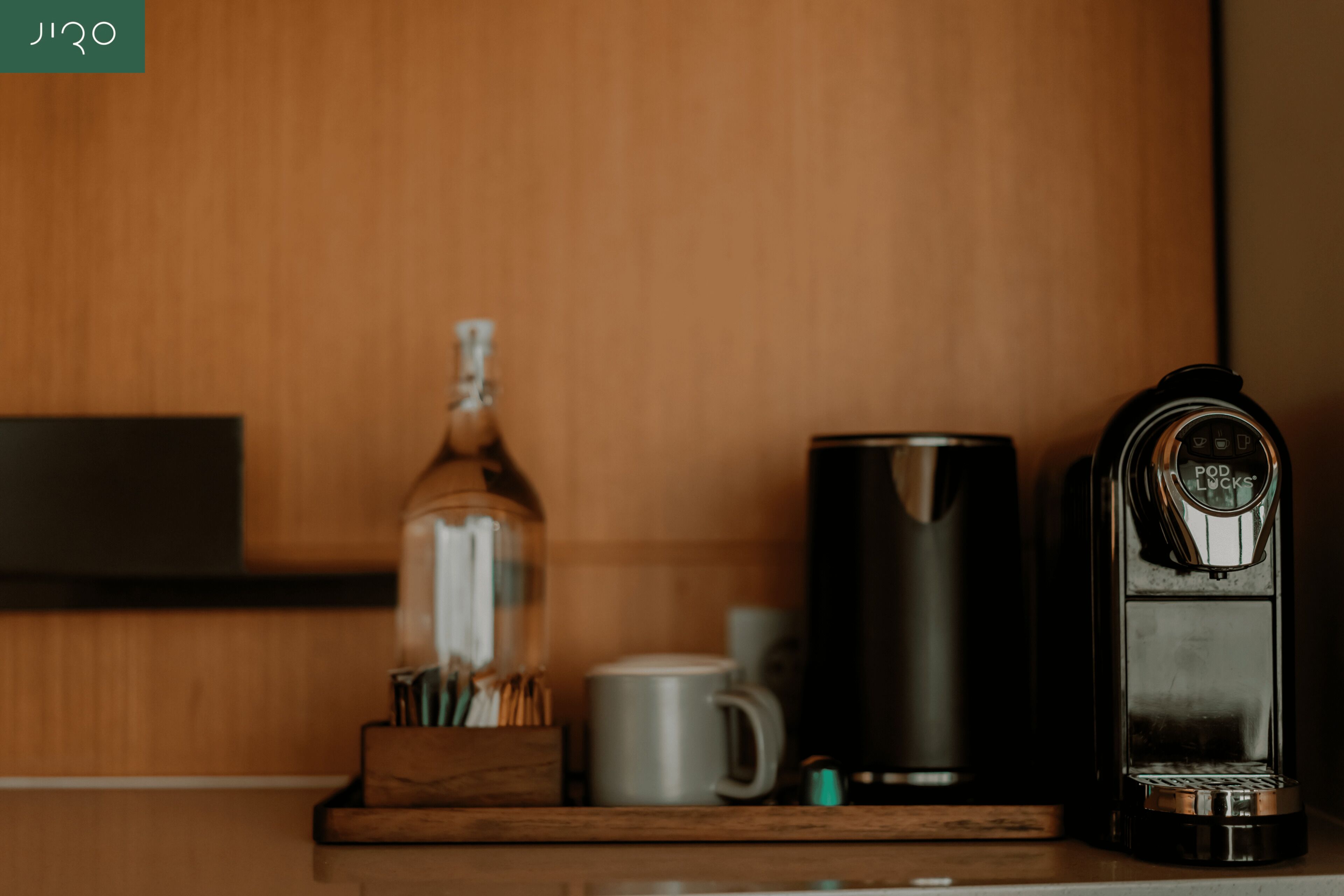 A kitchen counter with a coffee maker, a mug, and a bottle.