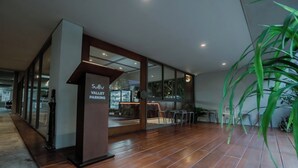 Une entrée moderne d’immeuble avec une enseigne indiquant « Vallet Parking ».
