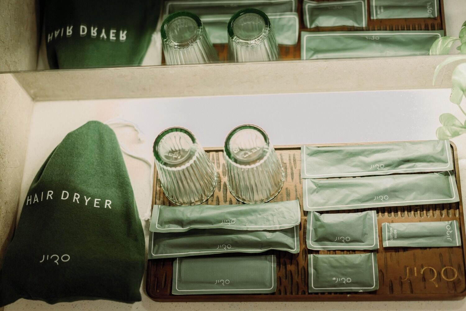 A hair dryer and various toiletries arranged on a tray.