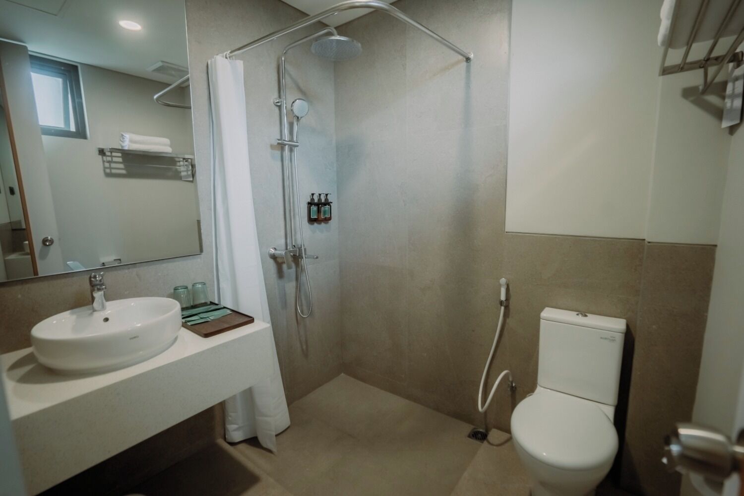 Un bagno moderno con lavandino, WC, doccia e specchio.