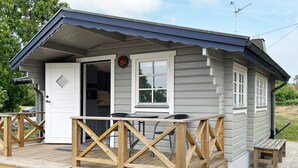A small wooden cabin with a porch, a door, and a window. - 4 Star Holiday Home in Drottningskar (Drottningskär)