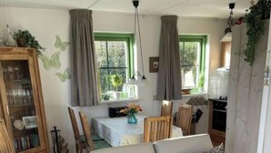 A living room with a sofa, dining area, and kitchen. - "sina" Comfortable Holiday Residence (Julianadorp)