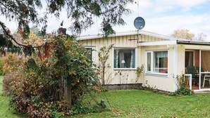 A single-story house with a satellite dish, a covered patio, and a small garden area with fallen leaves. - 4 Star Holiday Home in Mellbystrand (Mellbystrand)