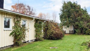 A single-story house with a sloped roof, a small front yard, and a wooden fence. - 4 Star Holiday Home in Mellbystrand (Mellbystrand)