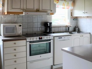 A compact kitchen with a microwave, stove, oven, and dishwasher. - 4 Star Holiday Home in Mellbystrand (Mellbystrand)