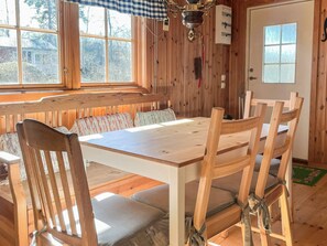 A wooden interior with a dining table, chairs, and a bench. - 5 Person Holiday Home in Borgholm (Borgholm)
