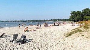 A beach with sun loungers, people relaxing, and a clear sky. - 5 Person Holiday Home in Borgholm (Borgholm)