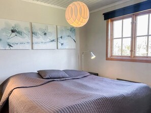 A bedroom with a bed, a desk, a lamp, and a window. - 5 Person Holiday Home in Borgholm (Borgholm)