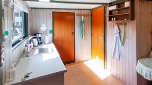 A compact kitchen with a sink, a stove, and a small countertop. - 2 Person Holiday Home in Skagen (Skagen)