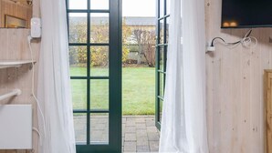 An open door with a view of a garden and a house in the background. - 2 Person Holiday Home in Skagen (Skagen)