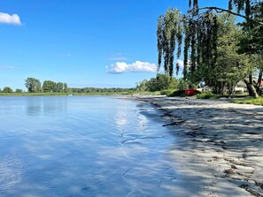 A calm lake with a sandy beach, trees, and a clear sky. - 4 Star Holiday Home in Solvesborg (Sölvesborg)