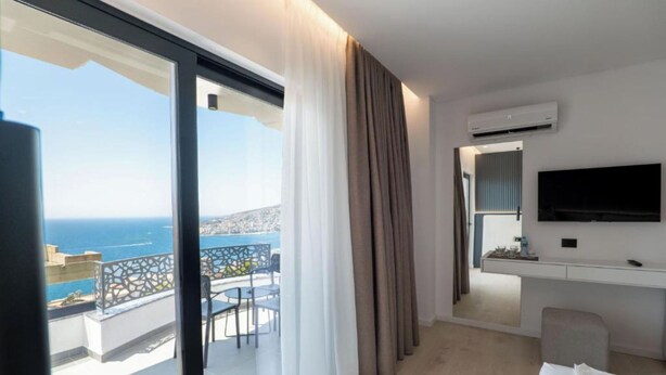 A modern hotel room with a balcony, a desk, and a TV. - Arrei Hotel (Sarandë)