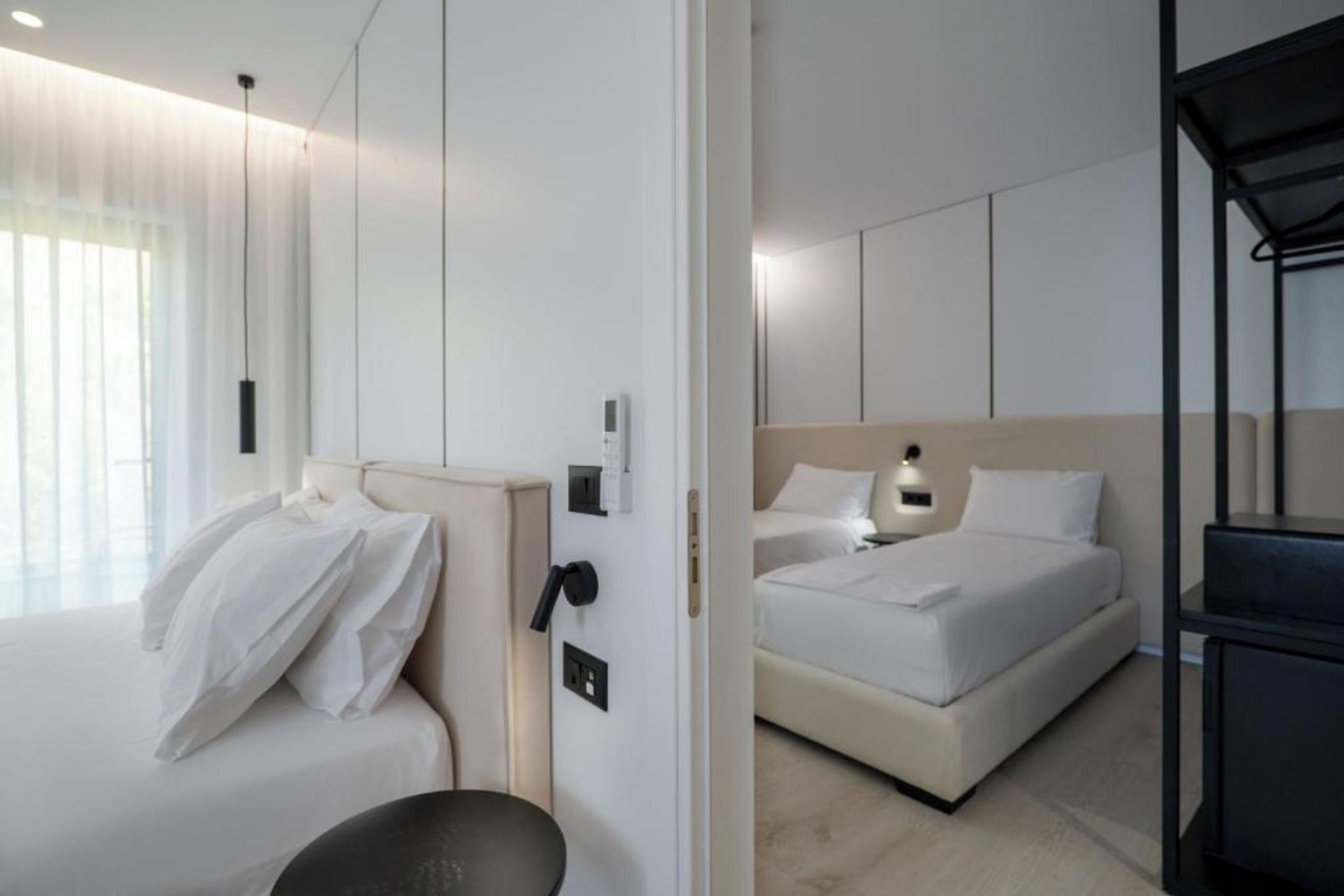 A modern hotel room with a large bed, a separate seating area, and a small desk.
