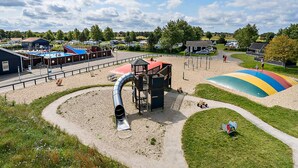 A playground with a slide, a climbing structure, and a colorful play area. - 4 Star Holiday Home in Asperup (Middelfart)